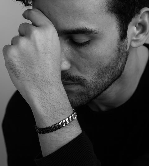 Black and white portrait of a man wearing a B.Tiff BG138BW two tone 8mm cuban link chain bracelet with a blurred background