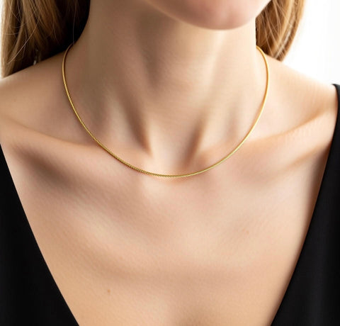 B.Tiff C015G Gold cable wire necklace made from surgical stainless steel plated with 18k gold on a female with a plain background