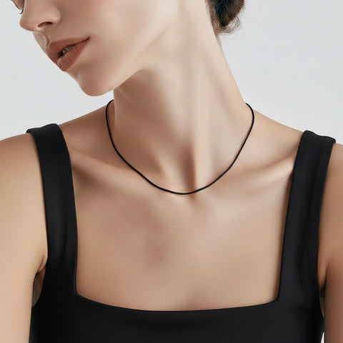Woman wearing a B.Tiff C015B black coil chain necklace against a neutral background