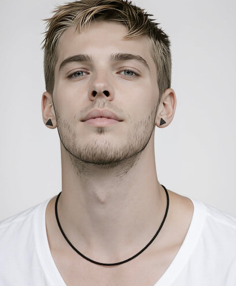 Man wearing a B.Tiff C060B black coil necklace and black earrings against a white background