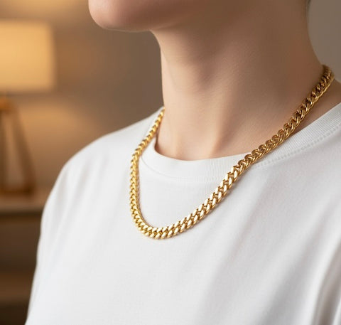 Person wearing a B.Tiff C138G 18k gold plated 8mm Cuban link chain necklace with a blurred background