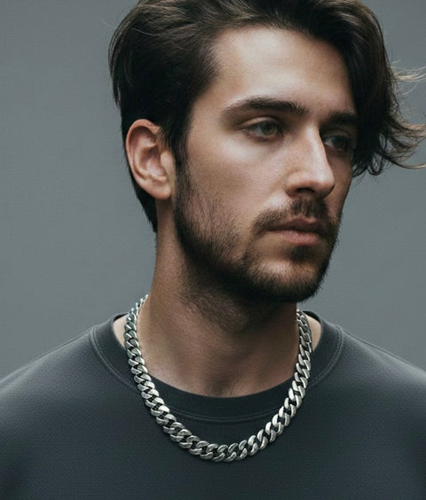 Man wearing a B.Tiff C160W 16mm silver Cuban link chain necklace against a gray background