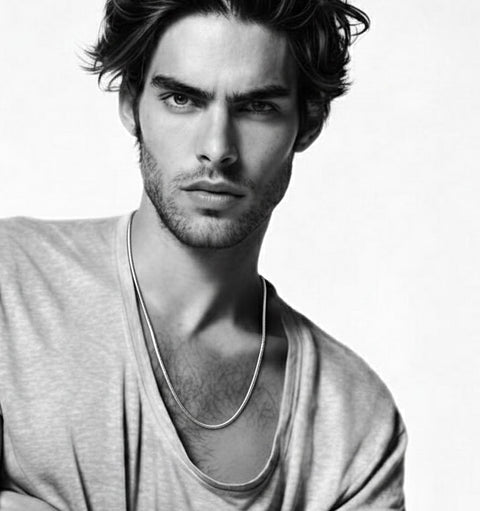 Black and white portrait of a man wearing a B.Tiff C060W coil chain necklace with a plain background