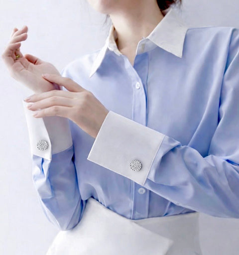 Light blue shirt with white collar and cuffs on a plain background