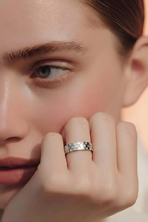 Close-up of a person wearing a B.Tiff RG104W Trellis silver pave diamond ring on their finger with a blurred background