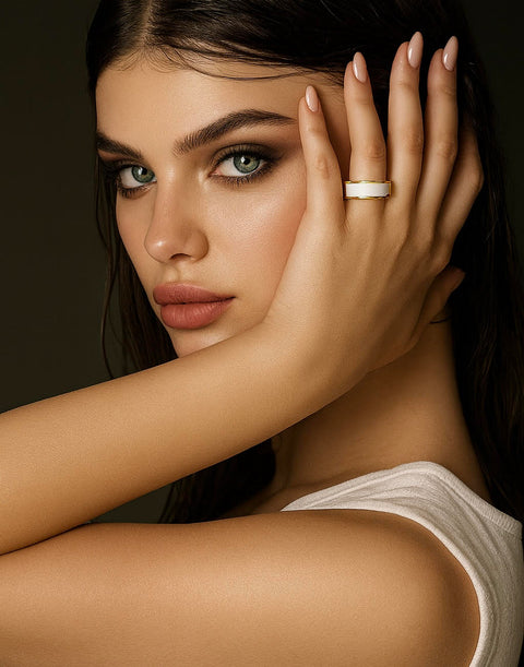 Woman wearing a B.Tiff RG800GW 18k gold plated white enamel ring with a dark background